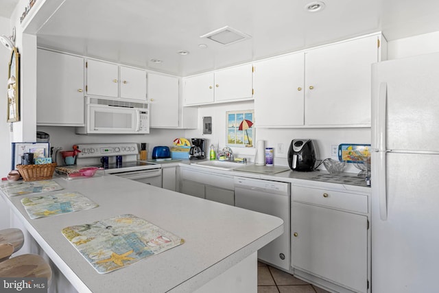 9400 Coastal Hwy Unit 1901, Ocean City, MD 21842 - kitchen featuring light countertops, a peninsula, white cabinets, white appliances, and a sink