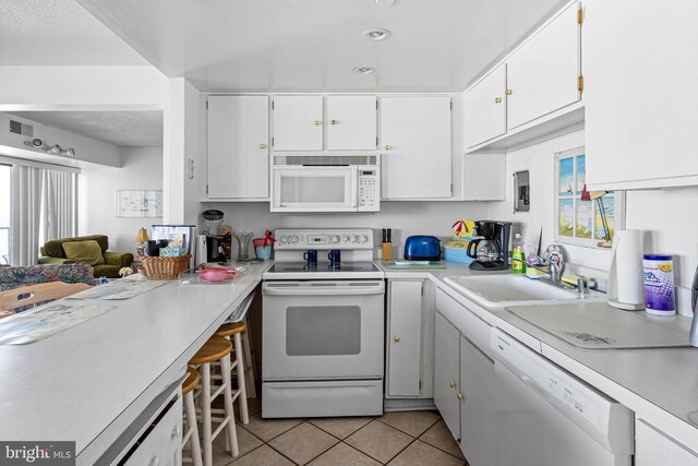 9400 Coastal Hwy Unit 1901, Ocean City, MD 21842 - kitchen with a sink, white cabinetry, white appliances, light countertops, and light tile patterned floors