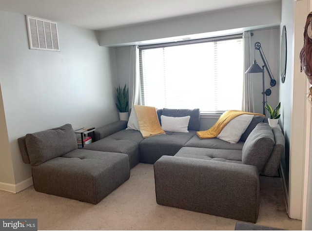 living area featuring baseboards and visible vents