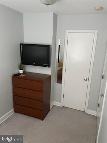 bedroom featuring light colored carpet and baseboards