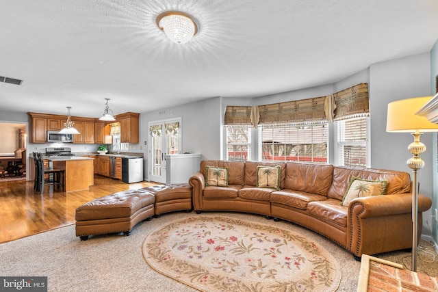 living room featuring visible vents and light wood-style floors