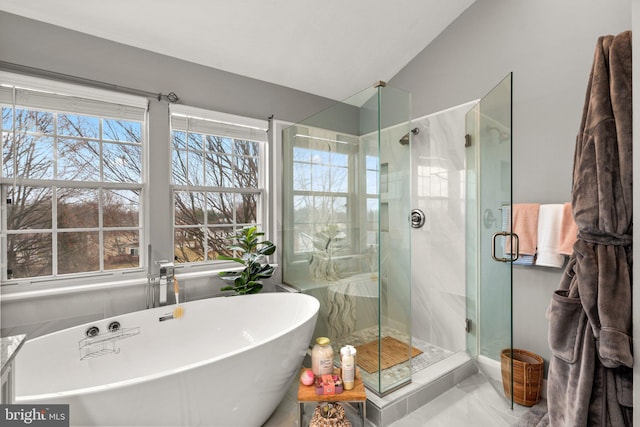 full bath featuring a shower stall, a freestanding tub, and lofted ceiling