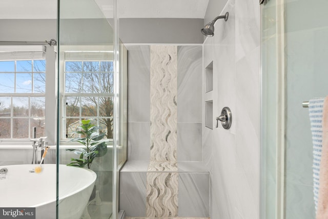 bathroom featuring a soaking tub and a shower