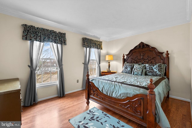 bedroom with wood finished floors, baseboards, and ornamental molding