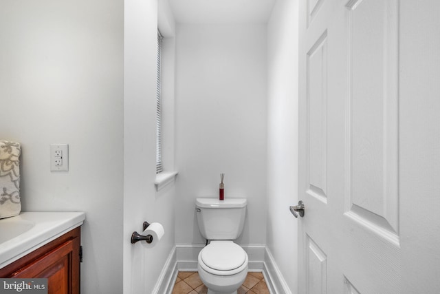 bathroom with tile patterned flooring, toilet, vanity, and baseboards