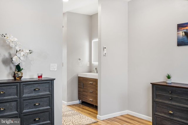 bathroom with vanity, baseboards, and wood finished floors