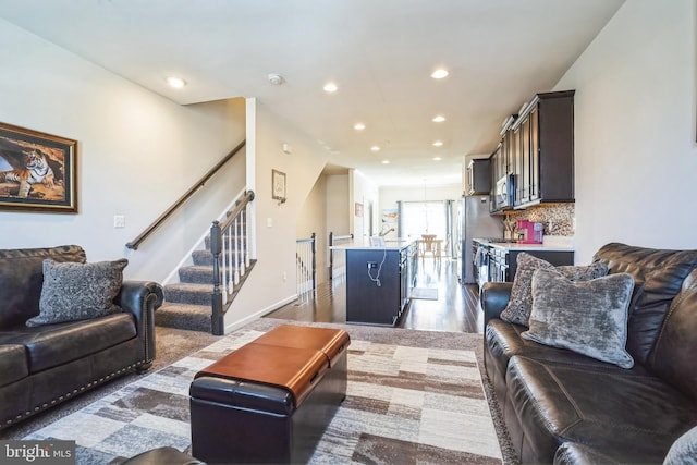 living room featuring baseboards, stairs, recessed lighting, and dark wood finished floors