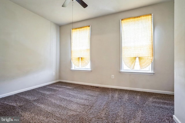 carpeted spare room featuring plenty of natural light, baseboards, and ceiling fan