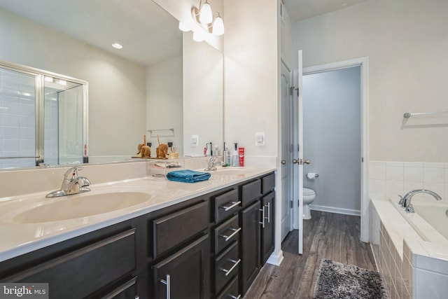 full bathroom with a garden tub, double vanity, a sink, and toilet