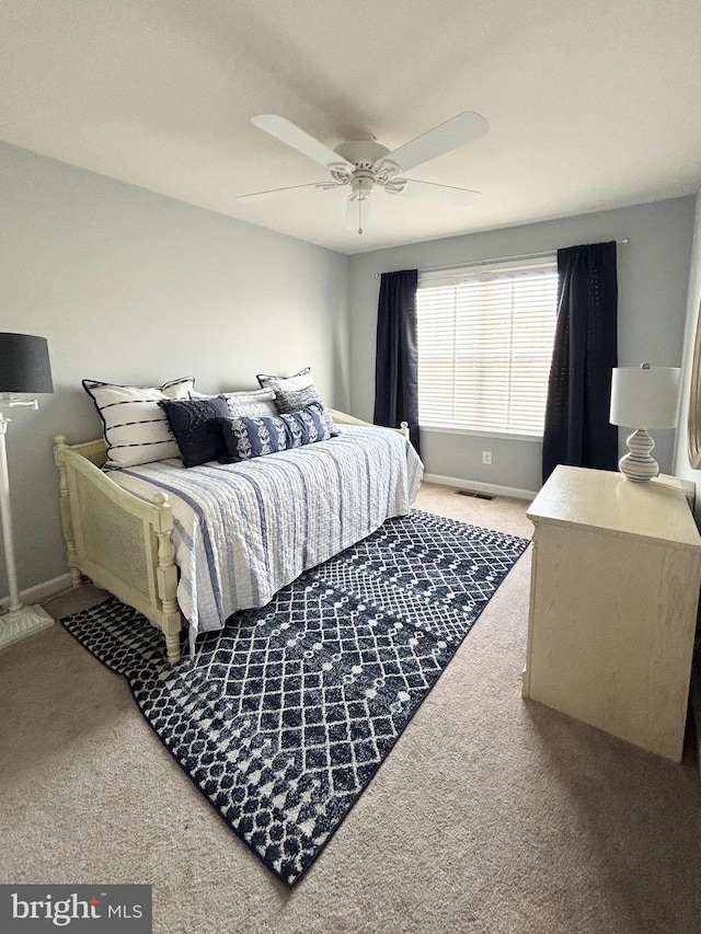 bedroom featuring baseboards, carpet flooring, a ceiling fan, and visible vents