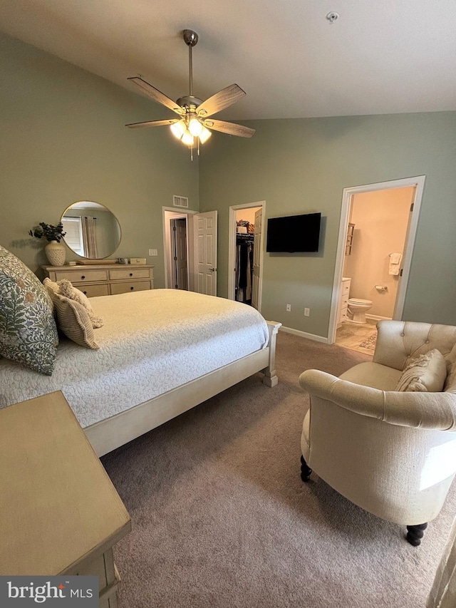 bedroom featuring visible vents, carpet floors, vaulted ceiling, ensuite bathroom, and a walk in closet