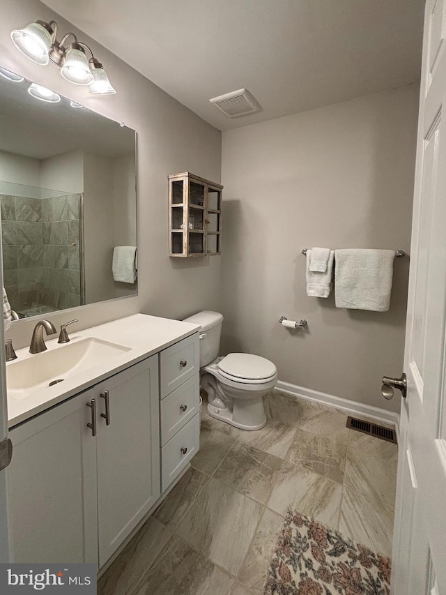 bathroom featuring visible vents, baseboards, toilet, and a tile shower