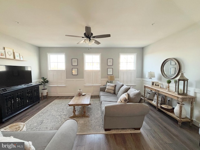 living room with a wainscoted wall, a healthy amount of sunlight, ceiling fan, and wood finished floors