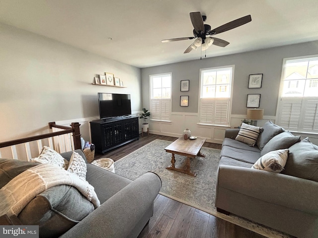 living room with ceiling fan, wood finished floors, and wainscoting