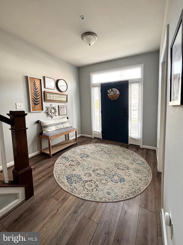 entryway with baseboards and wood finished floors