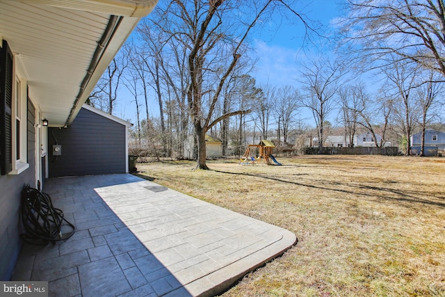 view of patio with a playground and fence