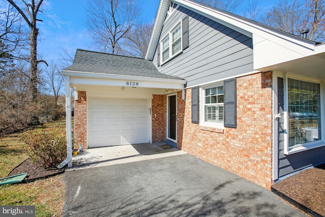 view of front of home featuring aphalt driveway, brick siding, roof with shingles, and an attached garage