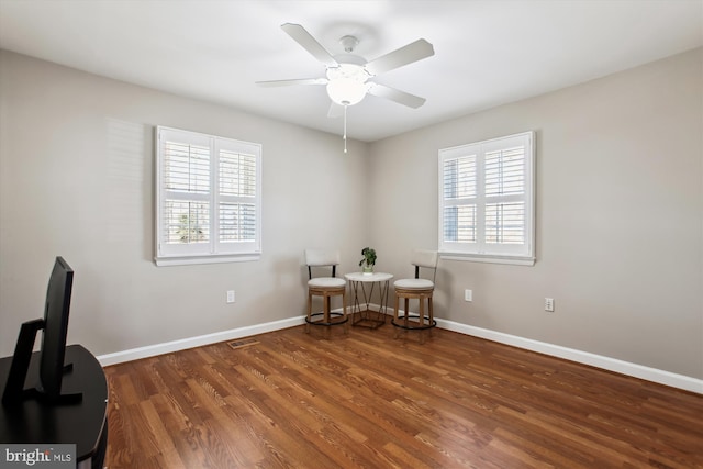 sitting room featuring a ceiling fan, visible vents, wood finished floors, and baseboards