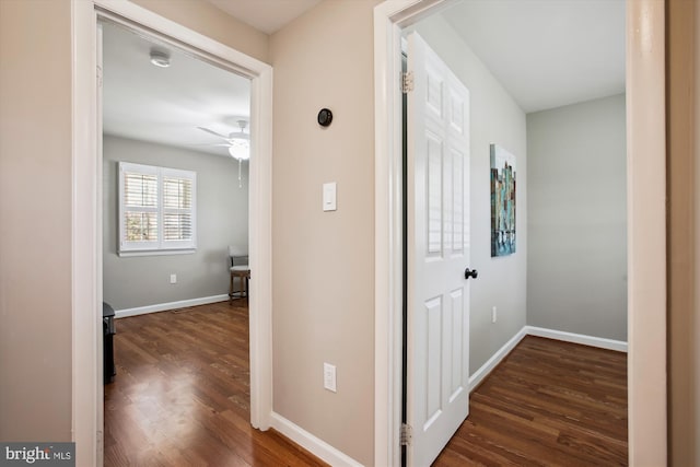 hall with dark wood-type flooring and baseboards