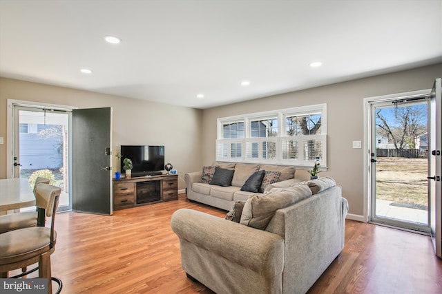 living room with recessed lighting, baseboards, and light wood-style floors