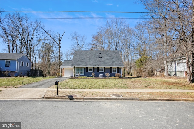 view of front of house featuring aphalt driveway, a garage, a shingled roof, and a front yard