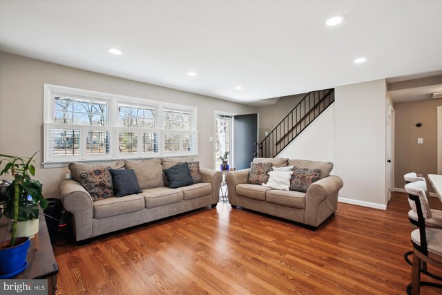 living room featuring recessed lighting, stairway, baseboards, and wood finished floors