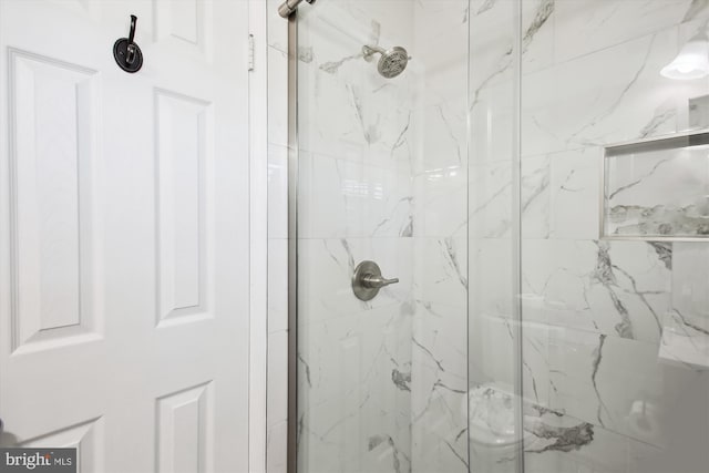 bathroom with a marble finish shower