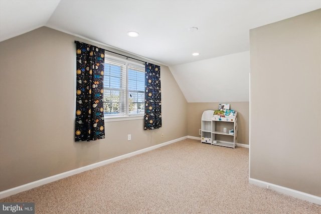 additional living space featuring baseboards, lofted ceiling, and carpet floors