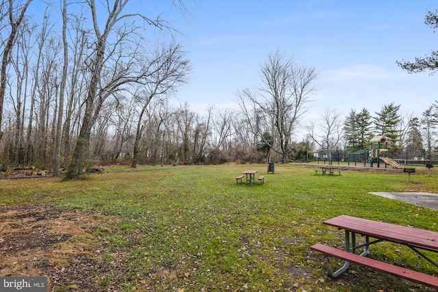 view of home's community featuring a lawn and playground community