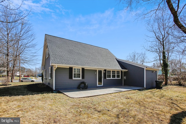 rear view of house with a shingled roof and a yard