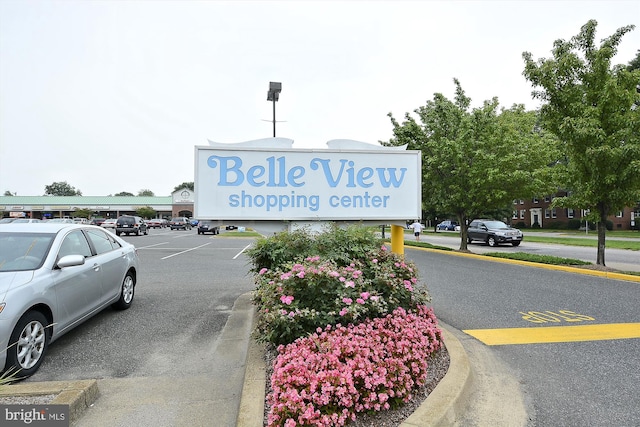 community / neighborhood sign featuring uncovered parking