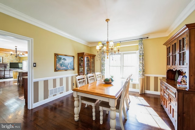 dining area featuring visible vents, crown molding, baseboards, dark wood-style floors, and a notable chandelier