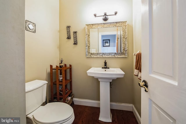 bathroom featuring toilet, wood finished floors, and baseboards