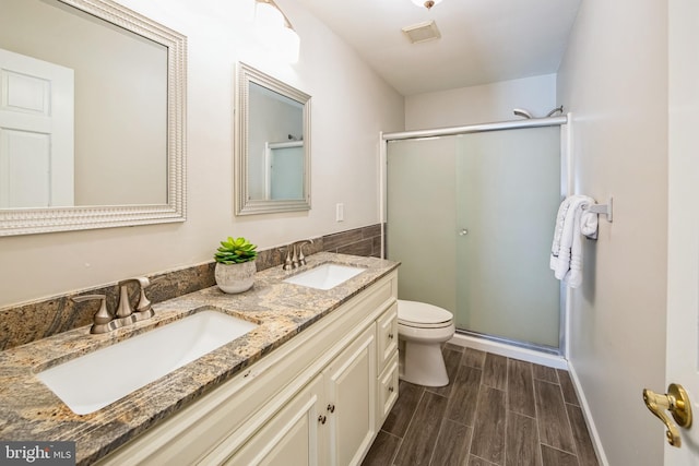 full bath featuring a shower stall, toilet, wood tiled floor, and a sink