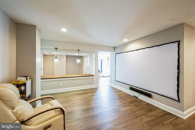 home theater room with recessed lighting, decorative columns, baseboards, and wood finished floors