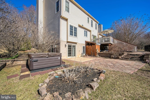 back of property featuring stucco siding, a deck, a hot tub, stairs, and a patio area