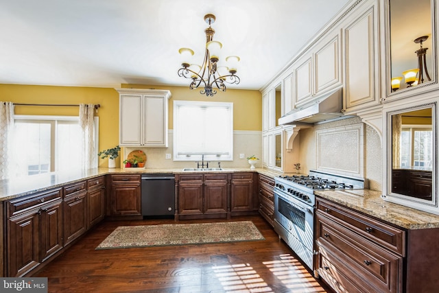 kitchen featuring a healthy amount of sunlight, under cabinet range hood, dishwashing machine, an inviting chandelier, and high end stainless steel range oven