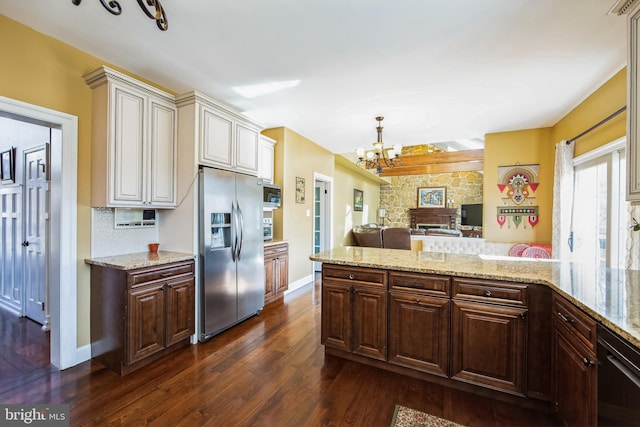 kitchen featuring light stone countertops, open floor plan, appliances with stainless steel finishes, an inviting chandelier, and dark wood-style flooring