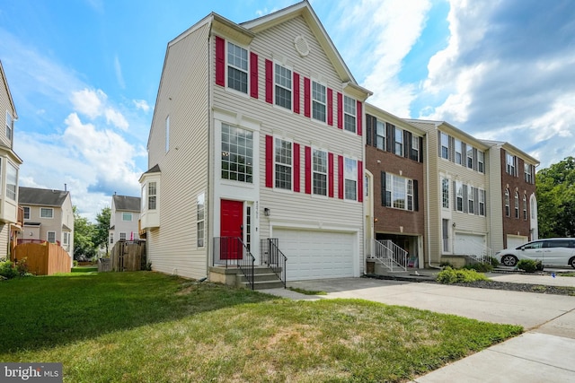 townhome / multi-family property with a residential view, driveway, a front yard, and a garage