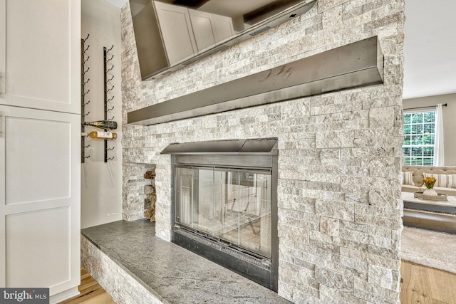 room details featuring a glass covered fireplace and wood finished floors