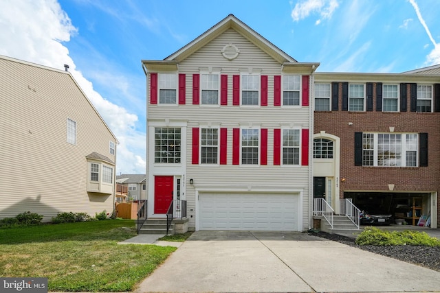 view of property featuring entry steps, a front yard, an attached garage, and driveway