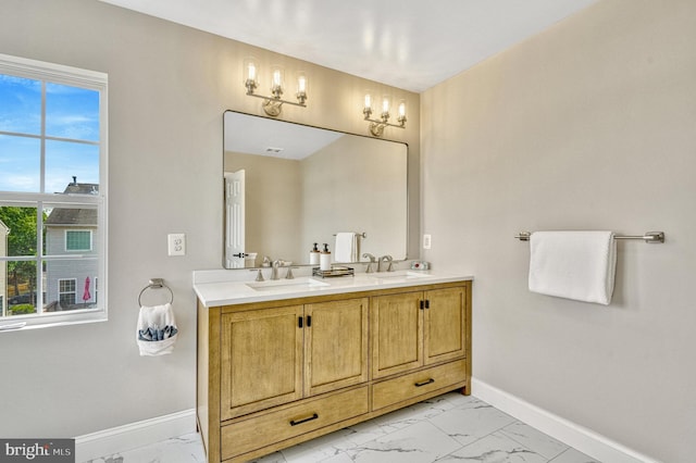 full bathroom featuring double vanity, baseboards, marble finish floor, and a sink