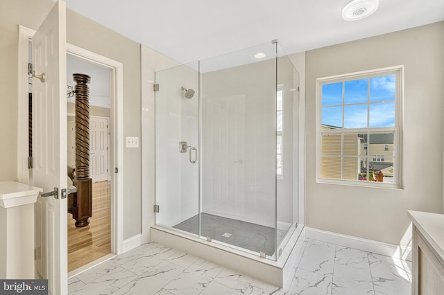 full bath with baseboards, vanity, marble finish floor, and a shower stall