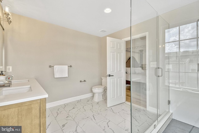 bathroom with toilet, marble finish floor, a stall shower, a sink, and baseboards