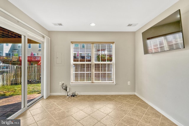 unfurnished room featuring visible vents, baseboards, and a healthy amount of sunlight