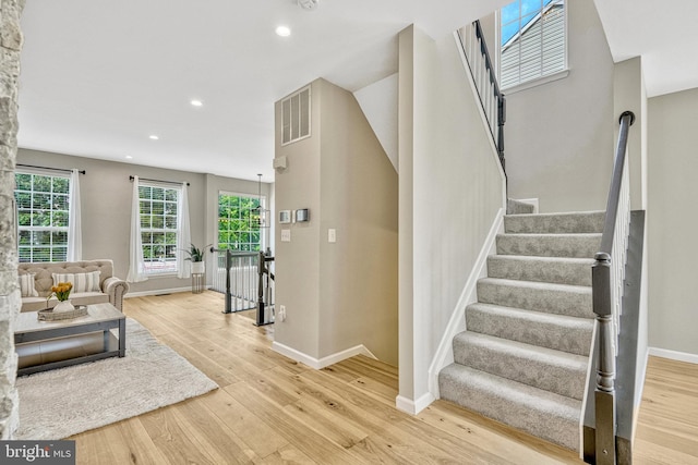 staircase featuring visible vents, recessed lighting, wood finished floors, and baseboards