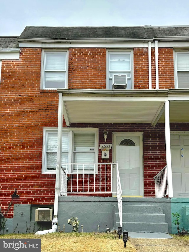 view of property with brick siding and a porch