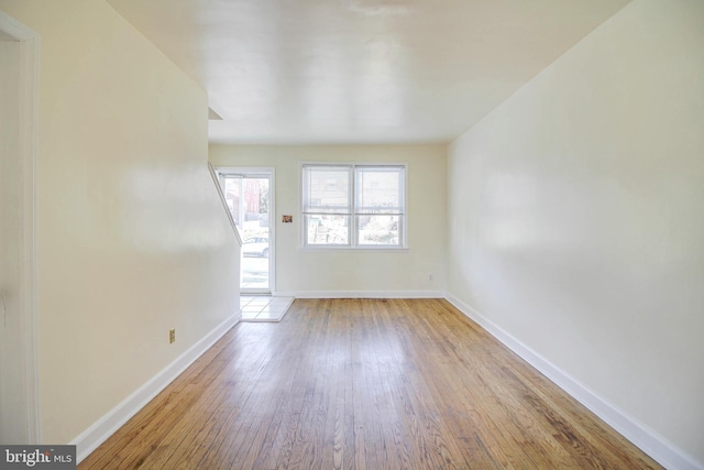 unfurnished room featuring baseboards and wood finished floors