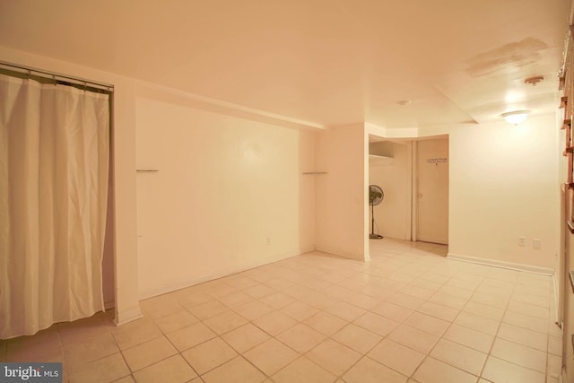 empty room featuring light tile patterned flooring and baseboards