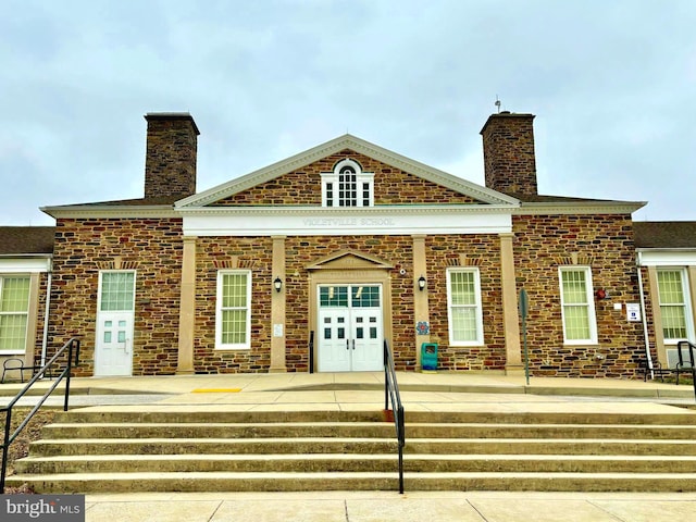 view of front of home featuring covered porch and a chimney